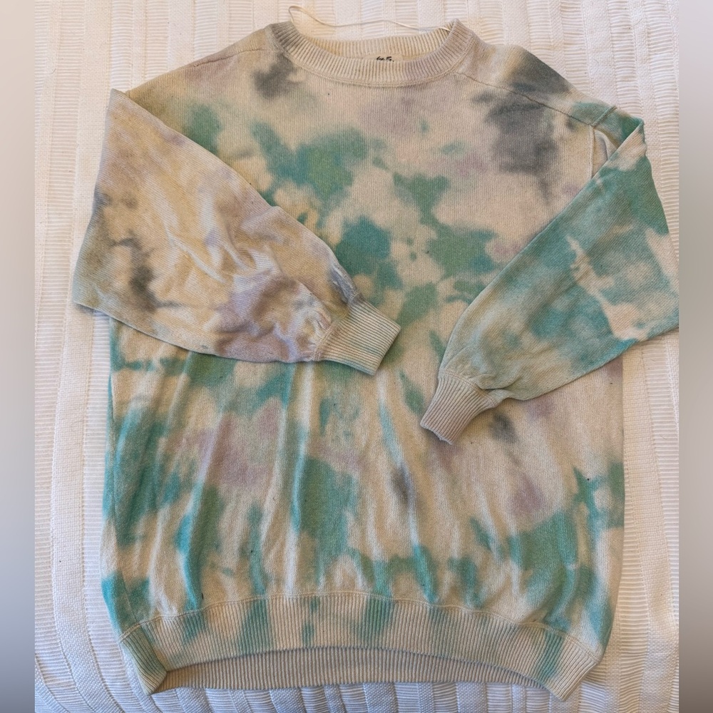 We the Free tie dye sweater. Green and purple on a cream background.